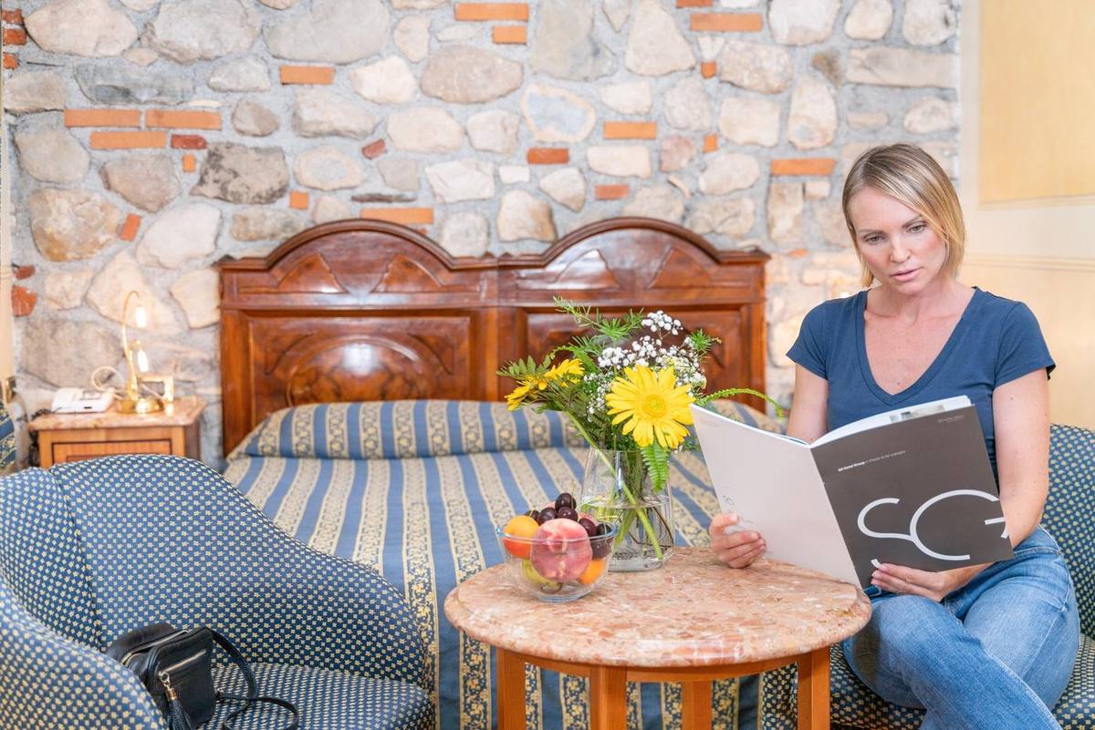 Un'ospite seduta in camera sfoglia la brochure dell'hotel