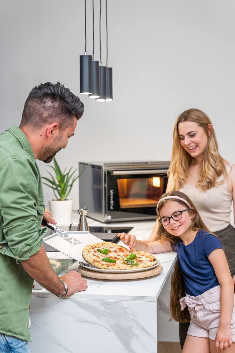 Una famiglia con una pizza e il forno Effeuno